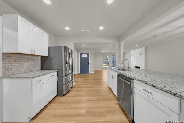 a large kitchen with stainless steel appliances lots of counter space and wooden floor