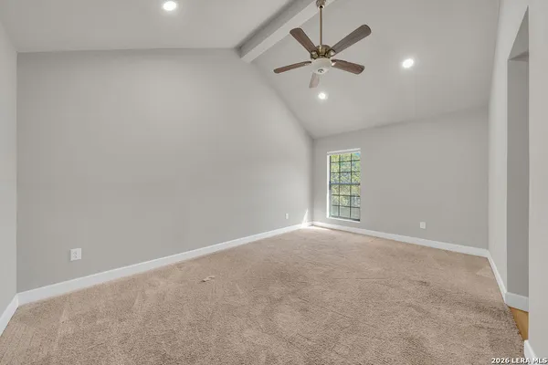 an empty room with windows and fan