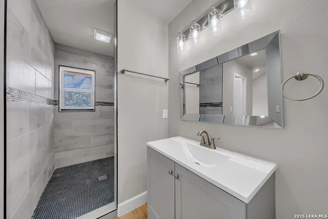 a bathroom with a sink a shower a mirror and a shower