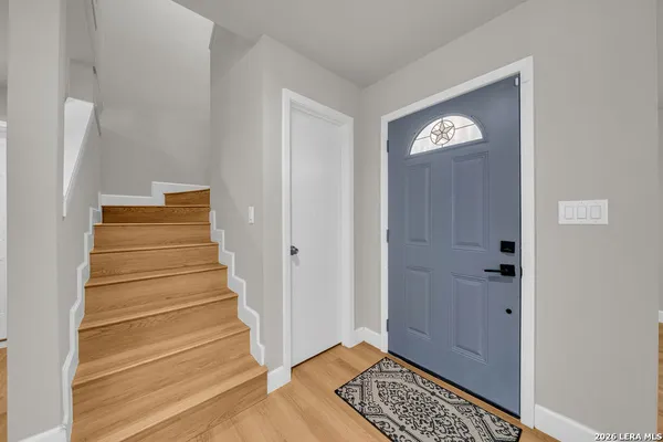 a view of an entryway with wooden floor and a hallway
