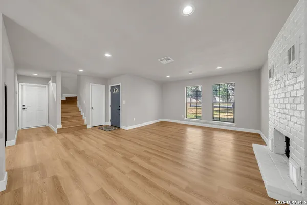 a view of an empty room with a fireplace and a window