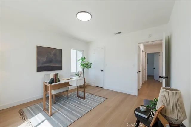 a spacious bedroom with a bed and wooden floor