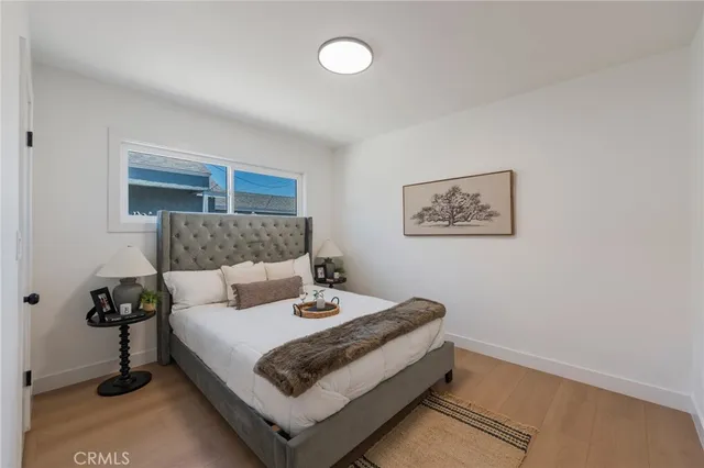 a large bedroom with a bed and large mirror with window