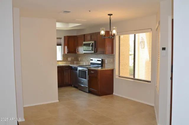 a kitchen with stainless steel appliances granite countertop a stove a sink and a refrigerator with wooden floor