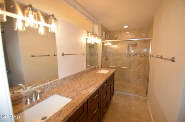 a bathroom with a granite countertop shower and a sink