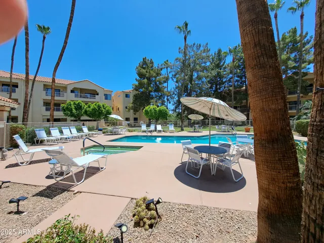 a view of a swimming pool with a patio and a yard