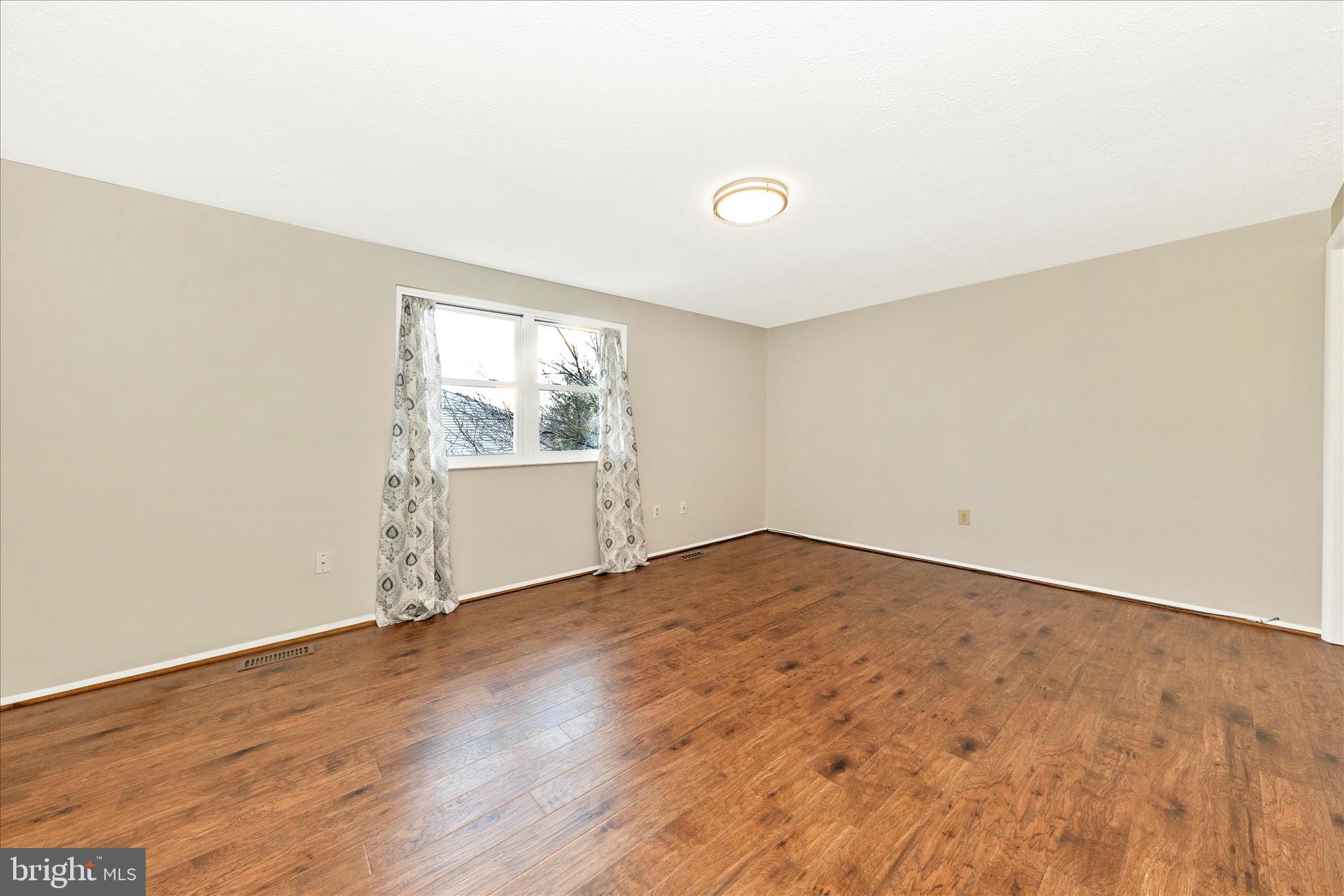 6616 Pebble Court Frederick, MD 21703 - Photo 15 of 33 an empty room with wooden floor and windows