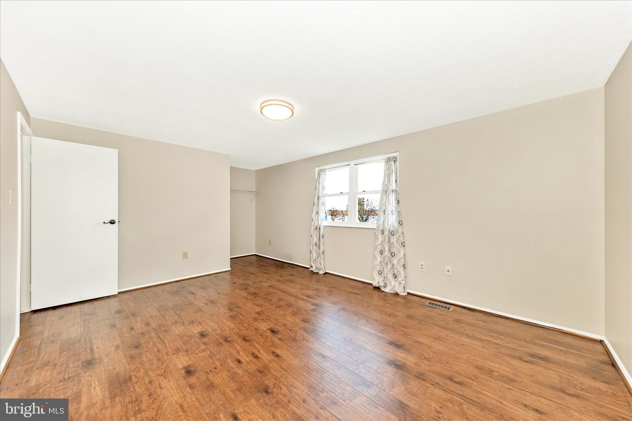 6616 Pebble Court Frederick, MD 21703 - Photo 17 of 33 an empty room with wooden floor and windows