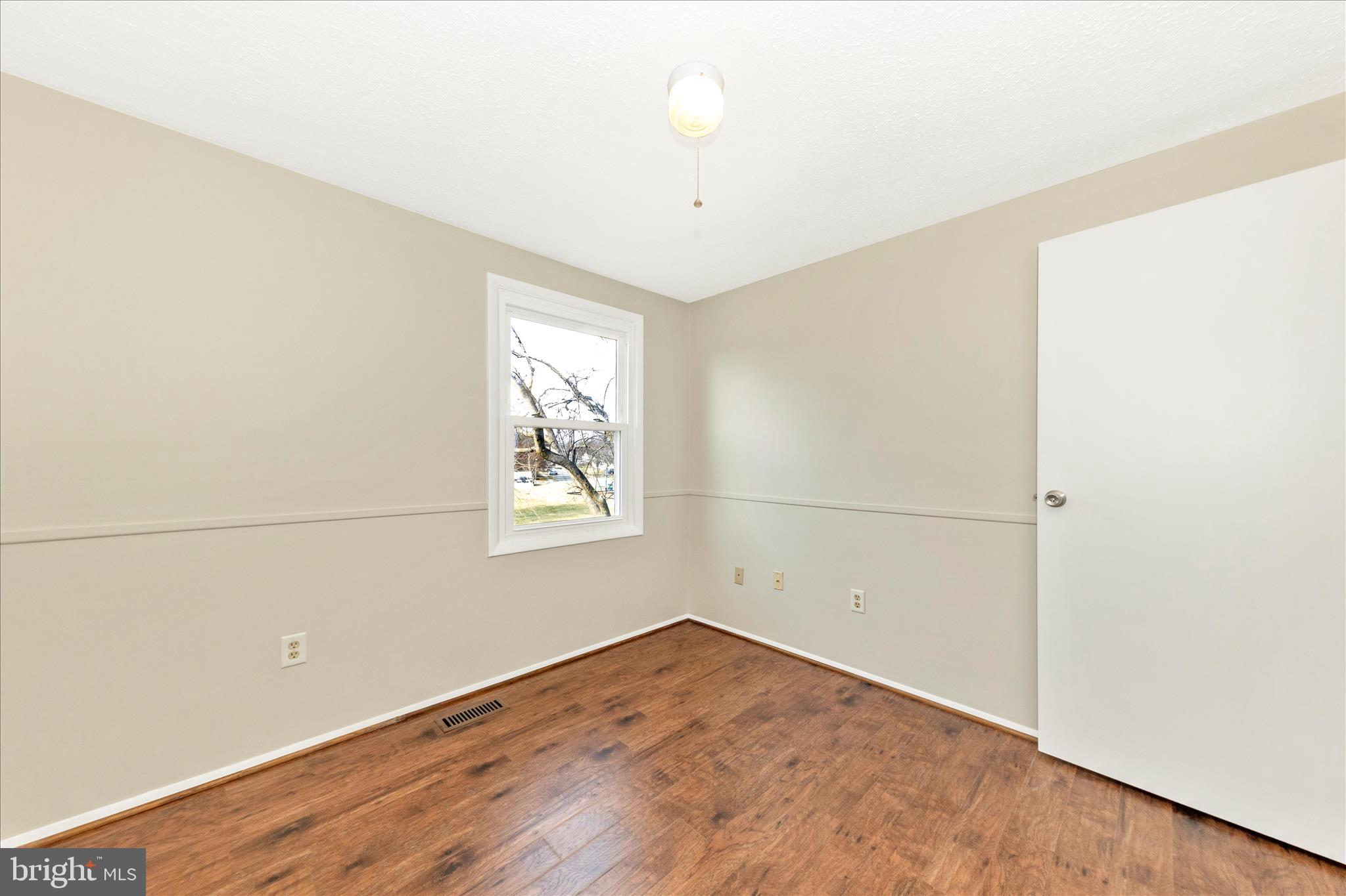 6616 Pebble Court Frederick, MD 21703 - Photo 21 of 33 an empty room with wooden floor and windows