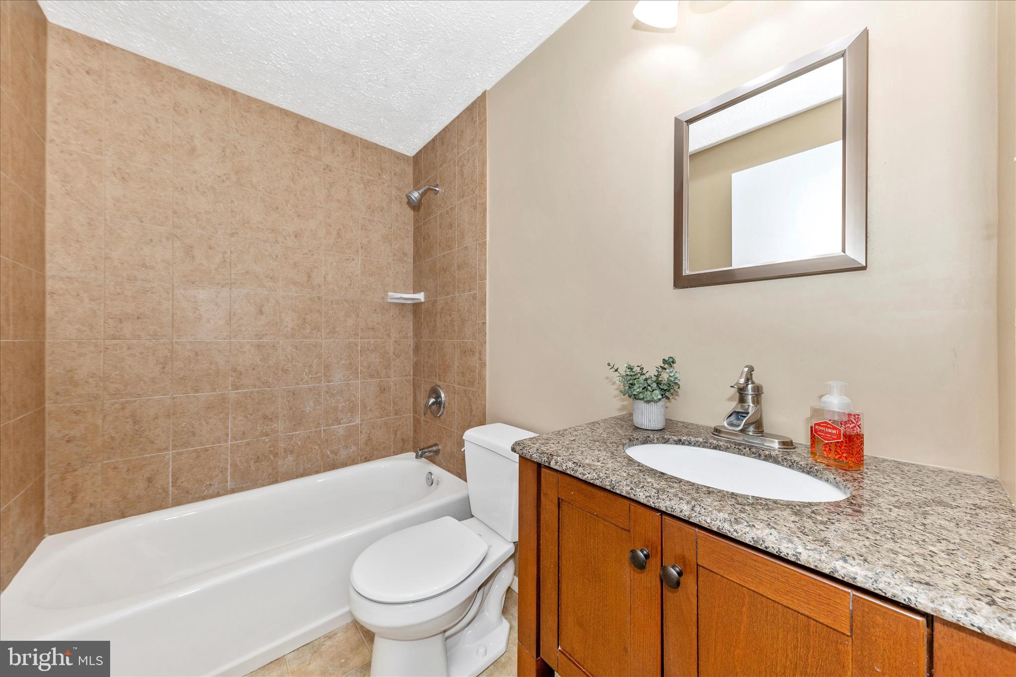 6616 Pebble Court Frederick, MD 21703 - Photo 23 of 33 a bathroom with a granite countertop sink a toilet and shower