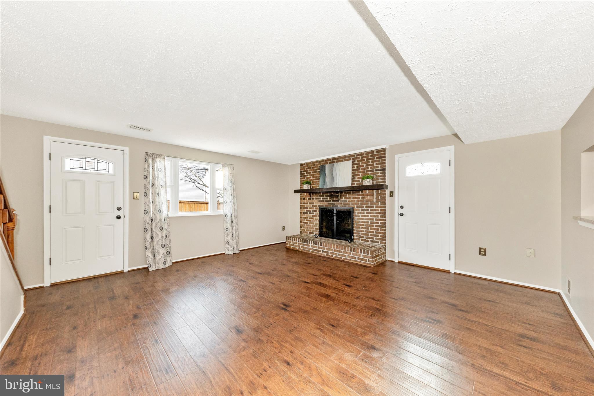 6616 Pebble Court Frederick, MD 21703 - Photo 8 of 33 an empty room with wooden floor and fireplace