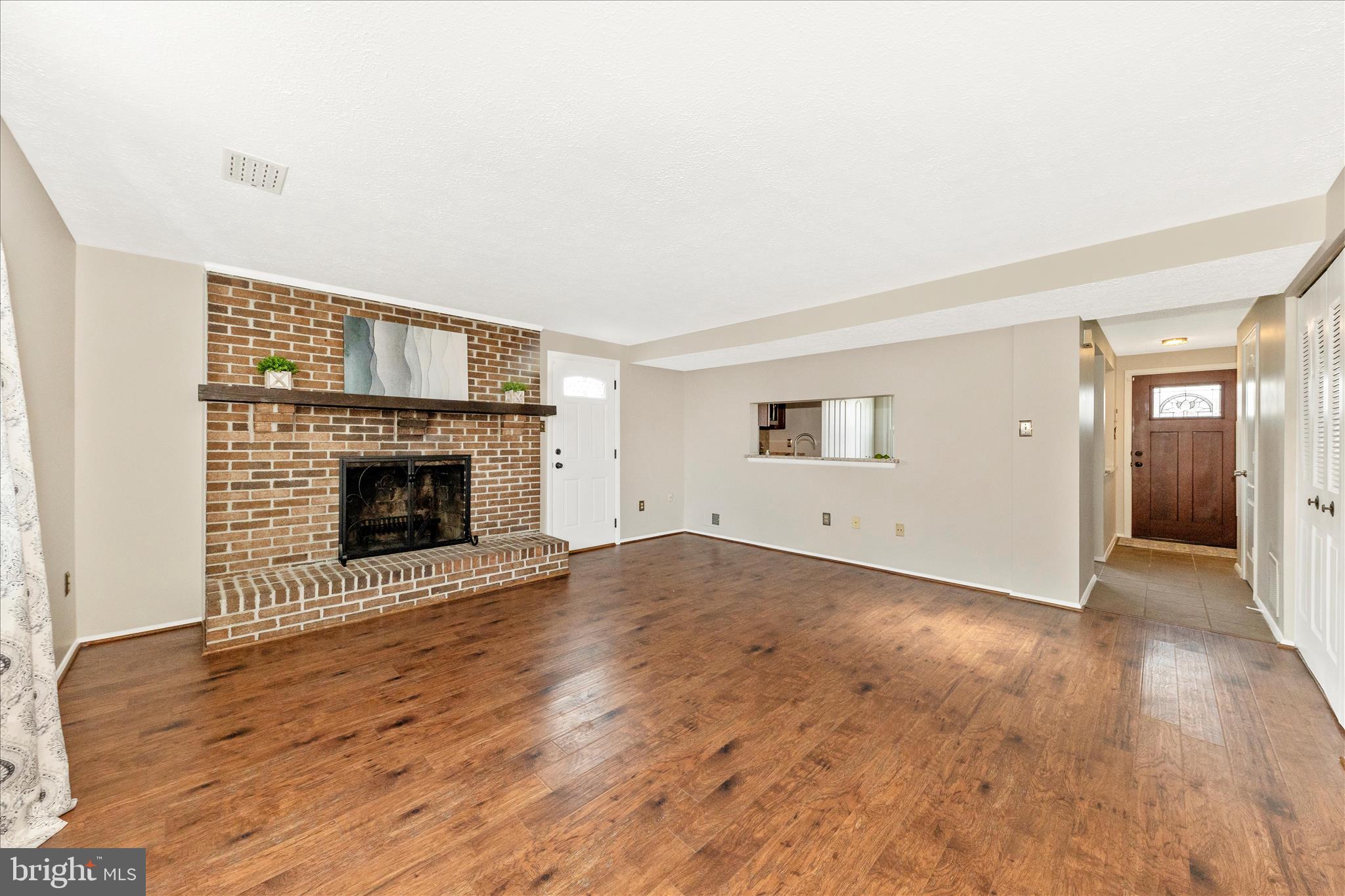 6616 Pebble Court Frederick, MD 21703 - Photo 9 of 33 a view of empty room with wooden floor and fireplace