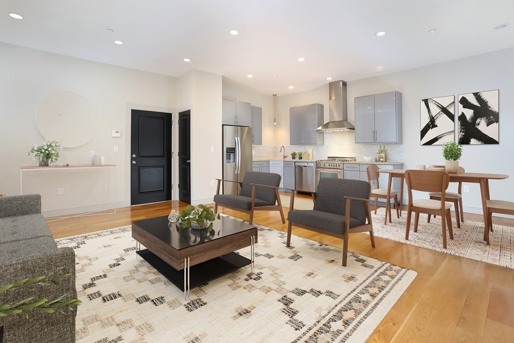 a living room with stainless steel appliances kitchen island granite countertop a rug kitchen view and living room