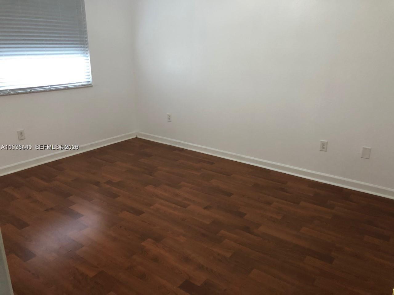 2925 Southeast 16th Avenue, Unit 202 Homestead, FL 33035 - Photo 11 of 11 an empty room with wooden floor and windows