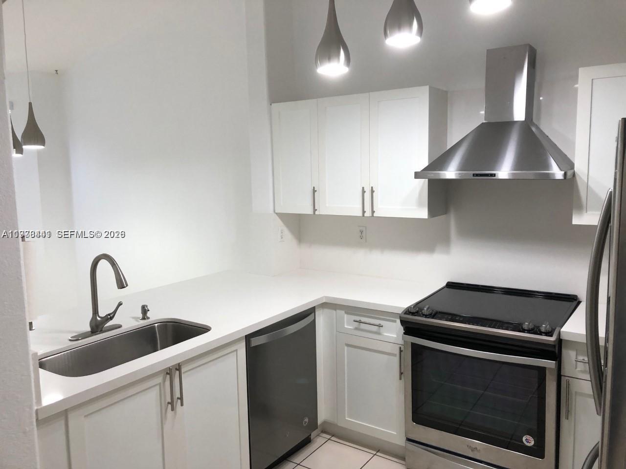 2925 Southeast 16th Avenue, Unit 202 Homestead, FL 33035 - Photo 2 of 11 a kitchen with a stove microwave and sink