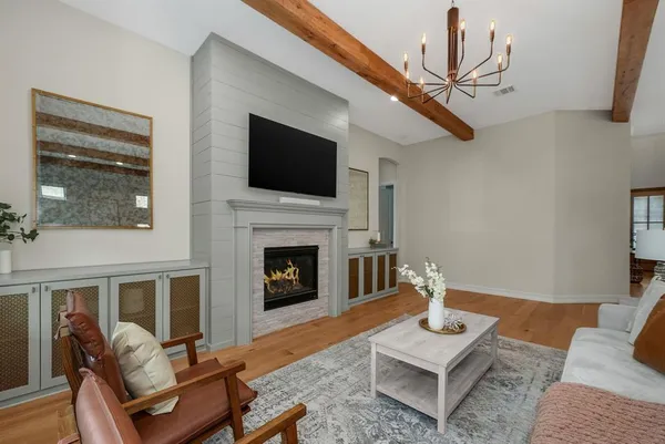 a living room with furniture a flat screen tv and a fireplace