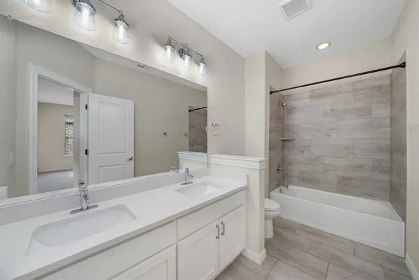 a bathroom with a double vanity sink mirror double and bathtub