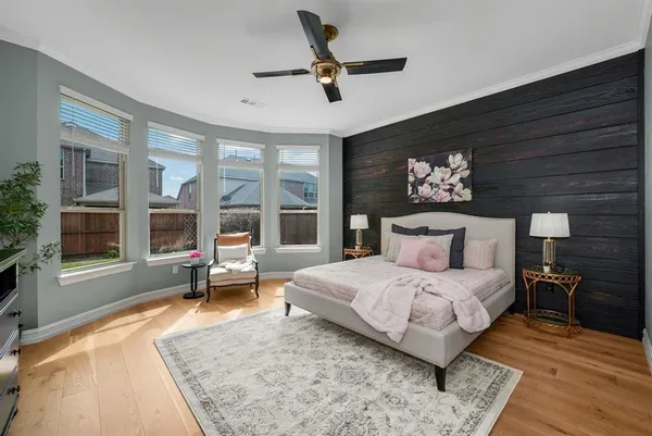 a bedroom with a large bed a flat screen tv and a couch