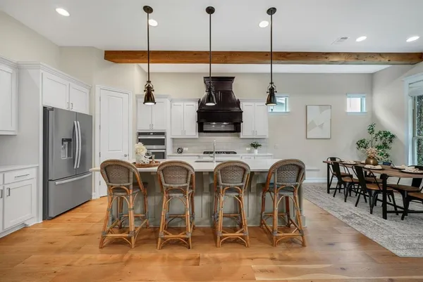 a kitchen with stainless steel appliances kitchen island granite countertop a dining table chairs and granite counter tops