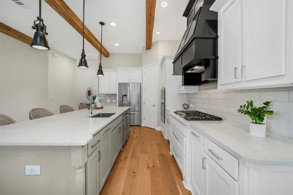 a kitchen with a sink a counter top space stainless steel appliances and cabinets