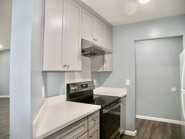 a kitchen with stainless steel appliances granite countertop a stove a refrigerator and a microwave