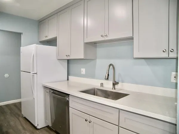 a kitchen with refrigerator and cabinets