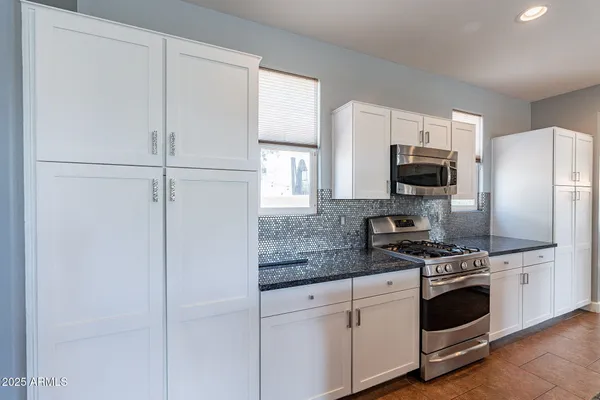 a kitchen with stainless steel appliances granite countertop a sink stove and refrigerator
