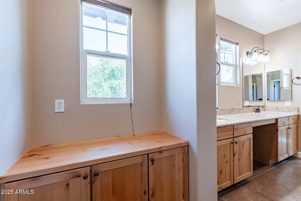 a bathroom with a granite countertop double vanity sink and mirror