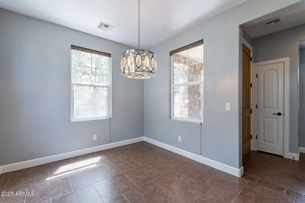 a view of a big room with windows and chandelier fan