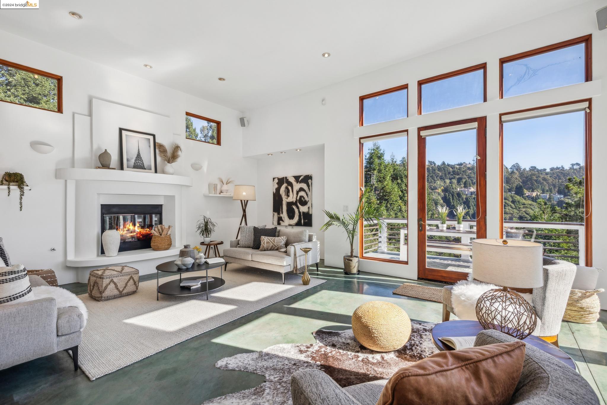 a living room with furniture a fireplace and a large window