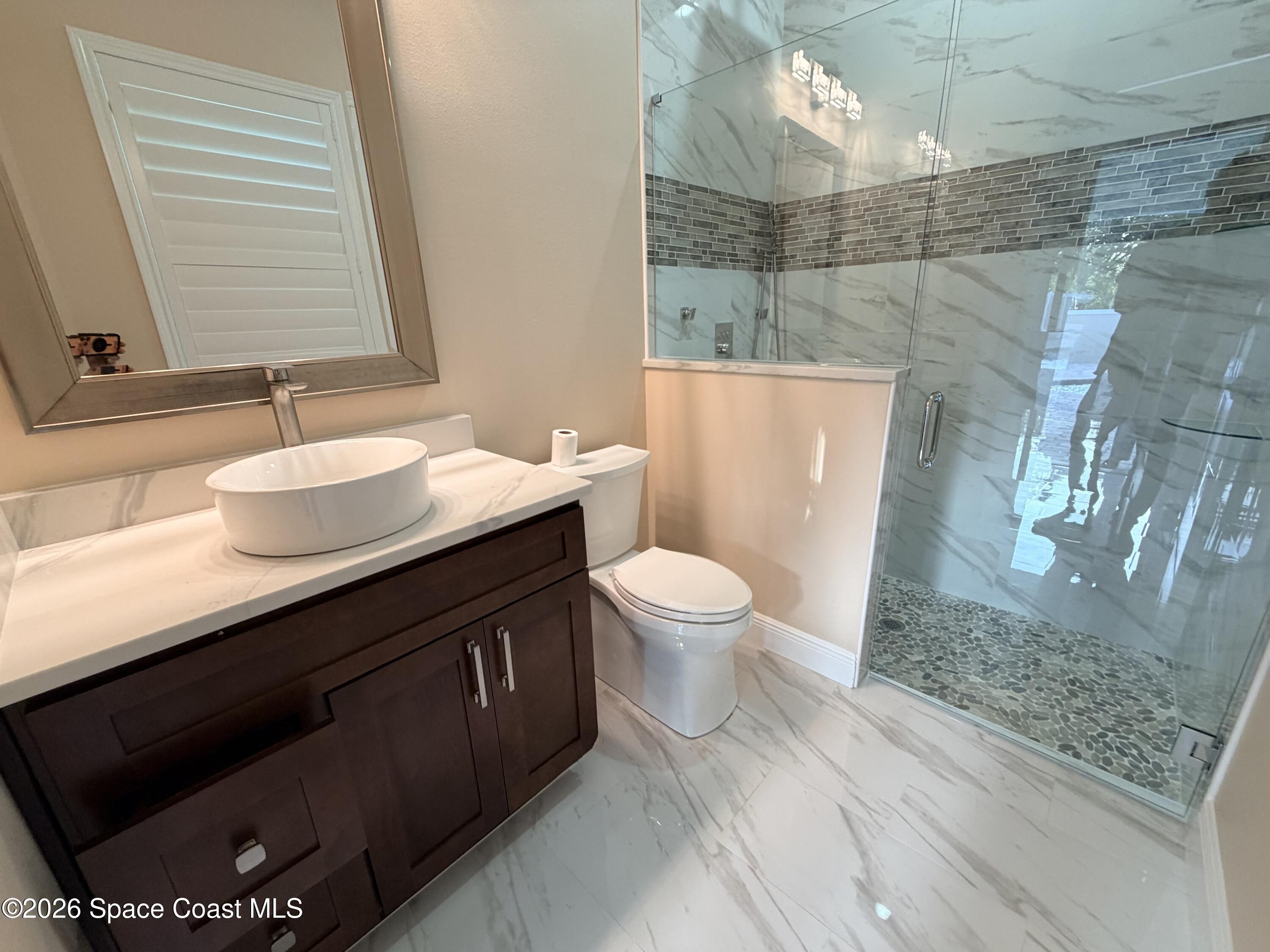 369 Tolley Avenue Melbourne, FL 32934 - Photo 26 of 33 a bathroom with a sink a toilet and shower