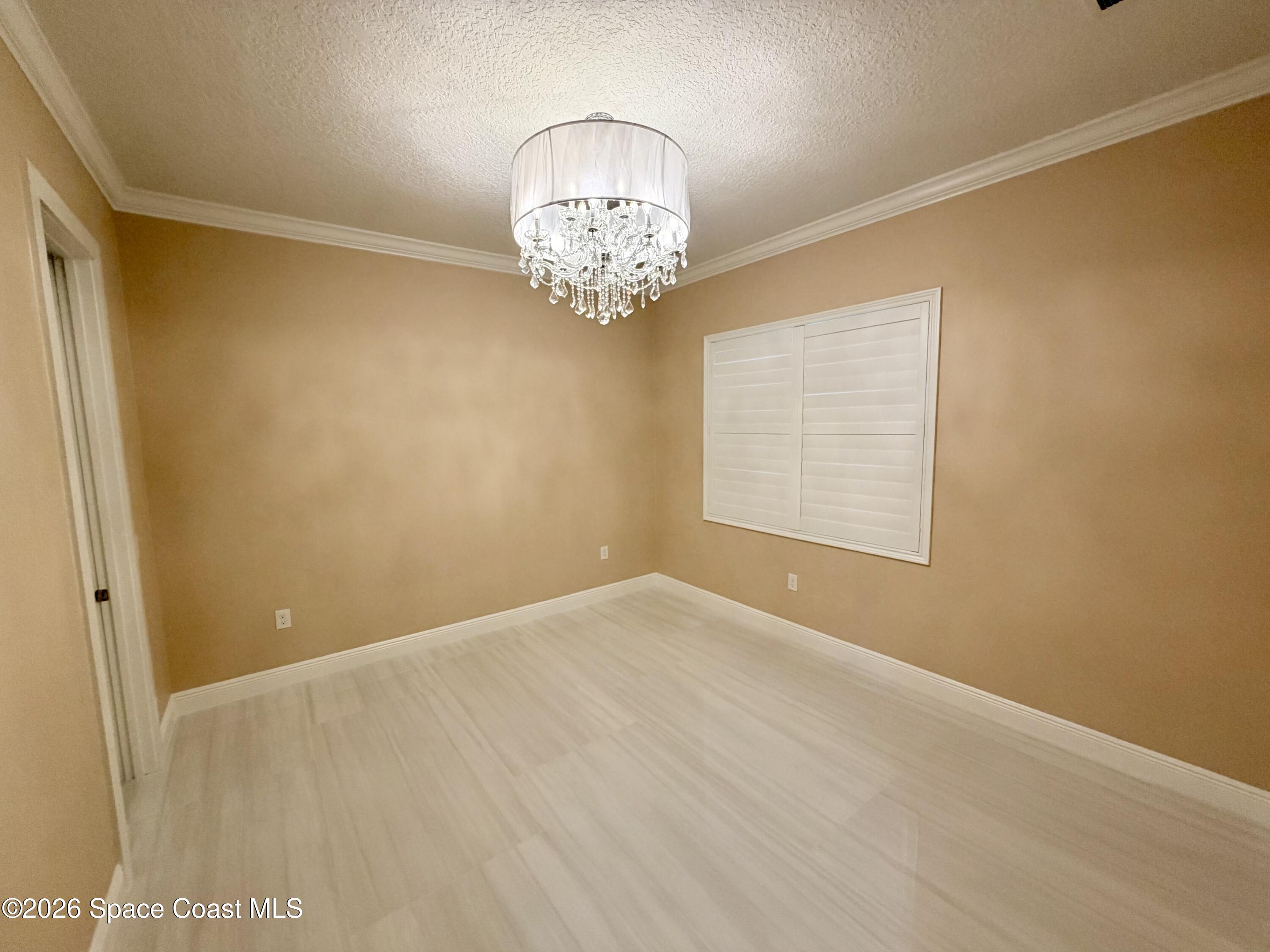 369 Tolley Avenue Melbourne, FL 32934 - Photo 28 of 33 an empty room with a chandelier fan