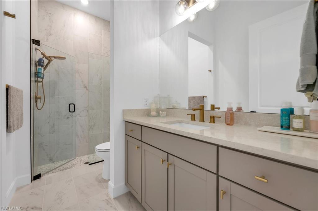 20557 Napa Loop Estero, FL 33928 - Photo 15 of 23 a bathroom with a granite countertop sink a toilet and shower