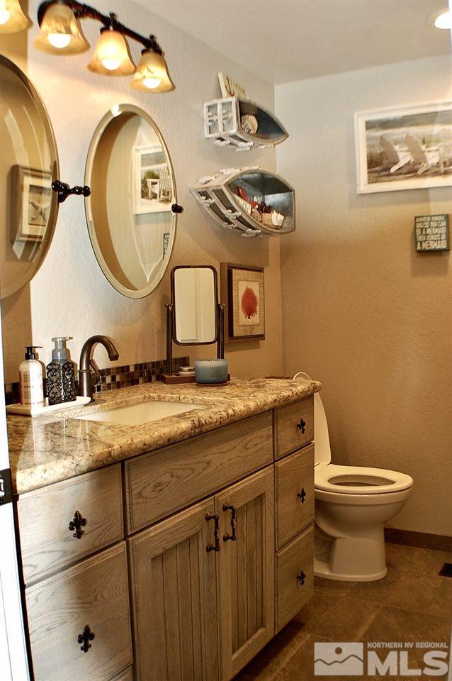1422 Calusa Lane Reno, NV 89523 - Photo 8 of 18 a bathroom with a granite countertop toilet sink and mirror