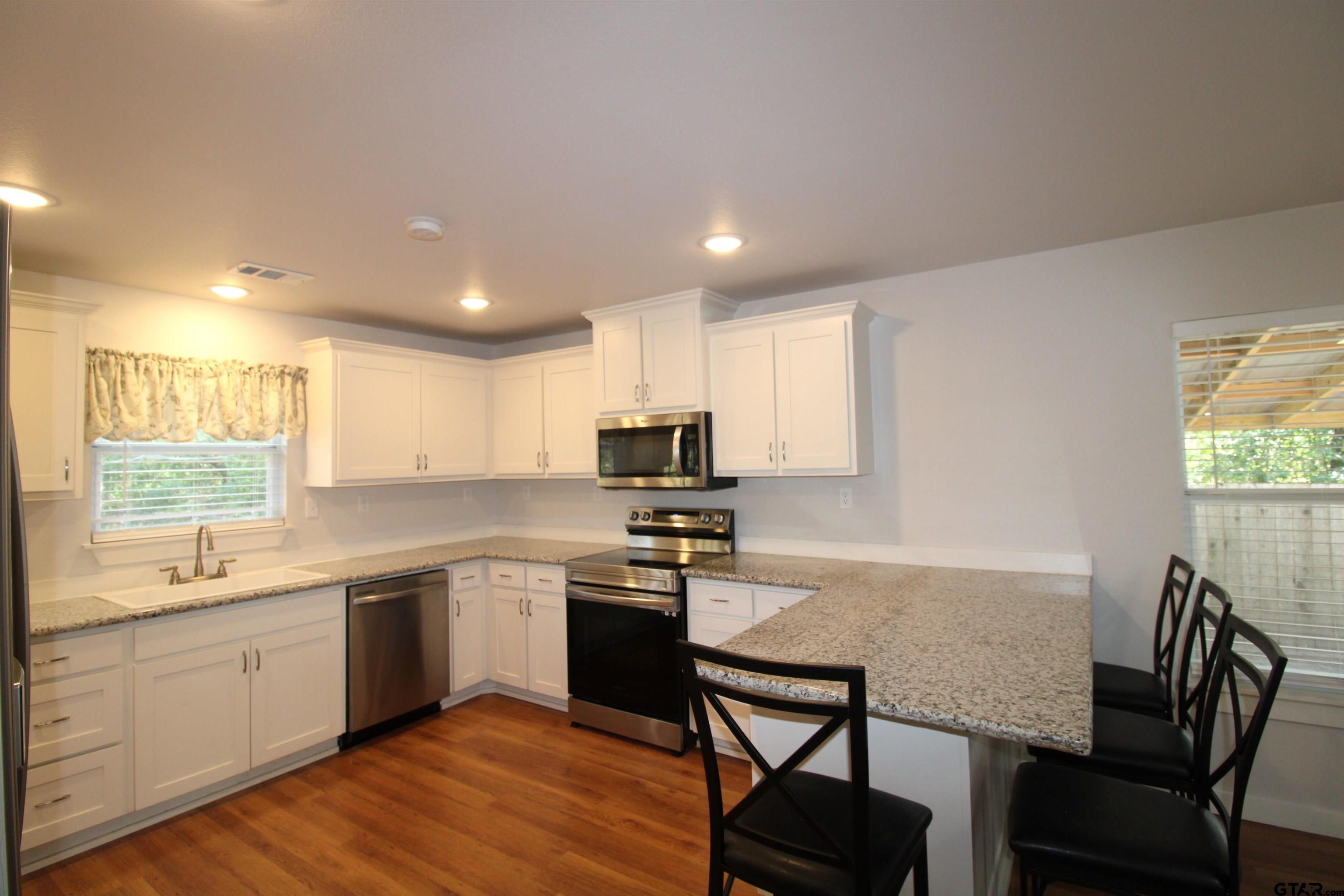 136 Long Shadow Drive Murchison, TX 75778 - Photo 9 of 19 a kitchen with a stove a sink a dining table and chairs
