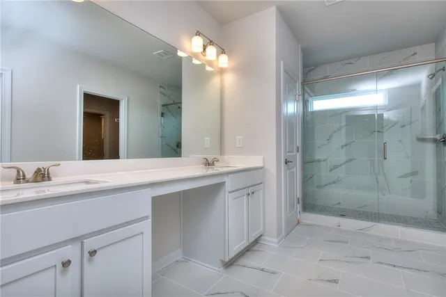 a bathroom with a double vanity sink mirror and shower