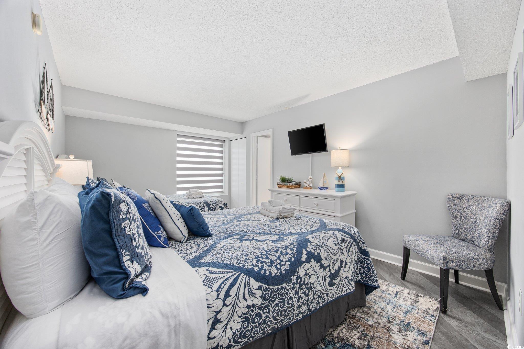 161 Seawatch Drive, Unit 1117 Myrtle Beach, SC 29572 - Photo 22 of 33 Bedroom featuring a textured ceiling and dark wood