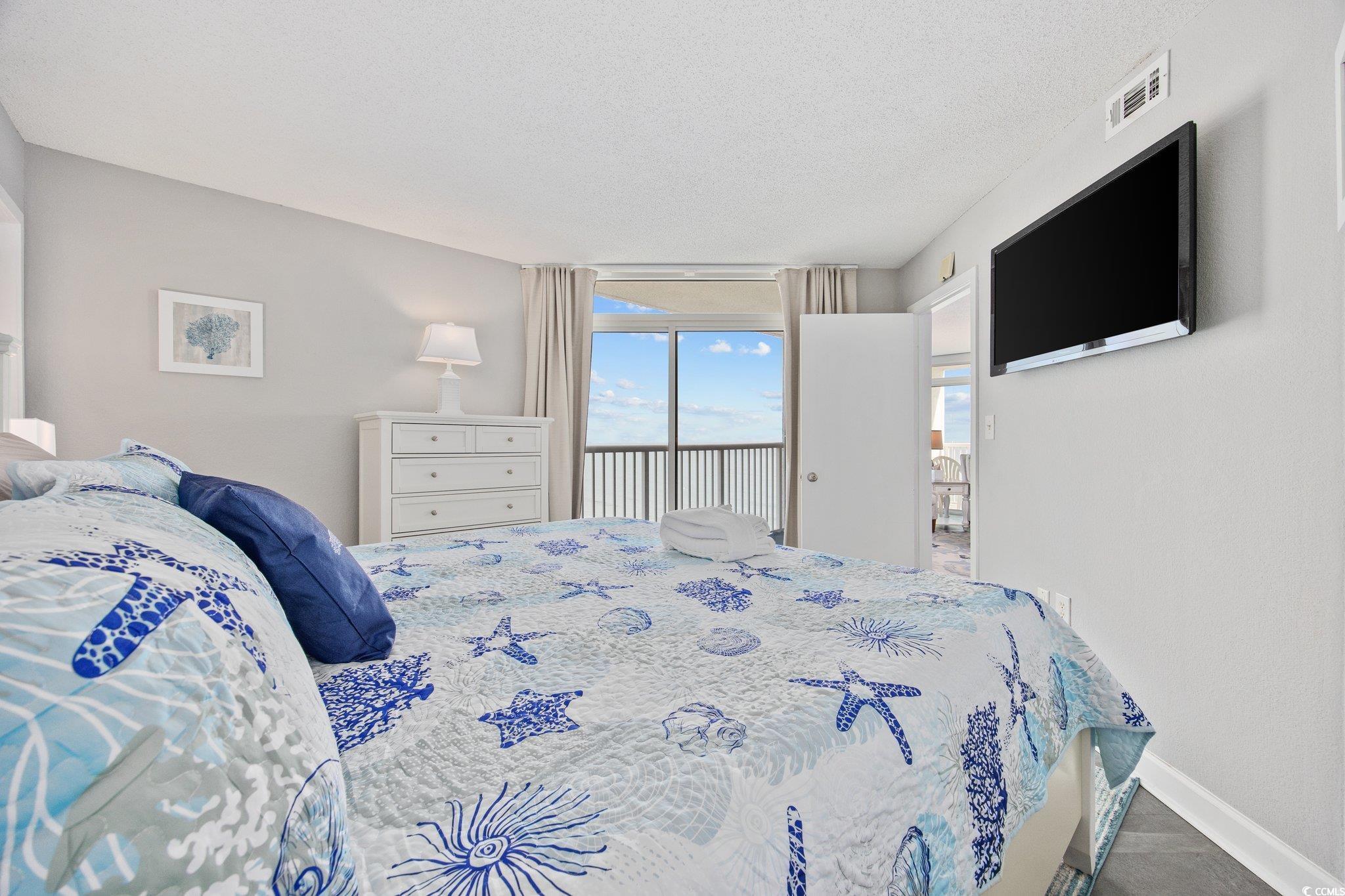 161 Seawatch Drive, Unit 1117 Myrtle Beach, SC 29572 - Photo 23 of 33 Bedroom featuring access to outside and a textured