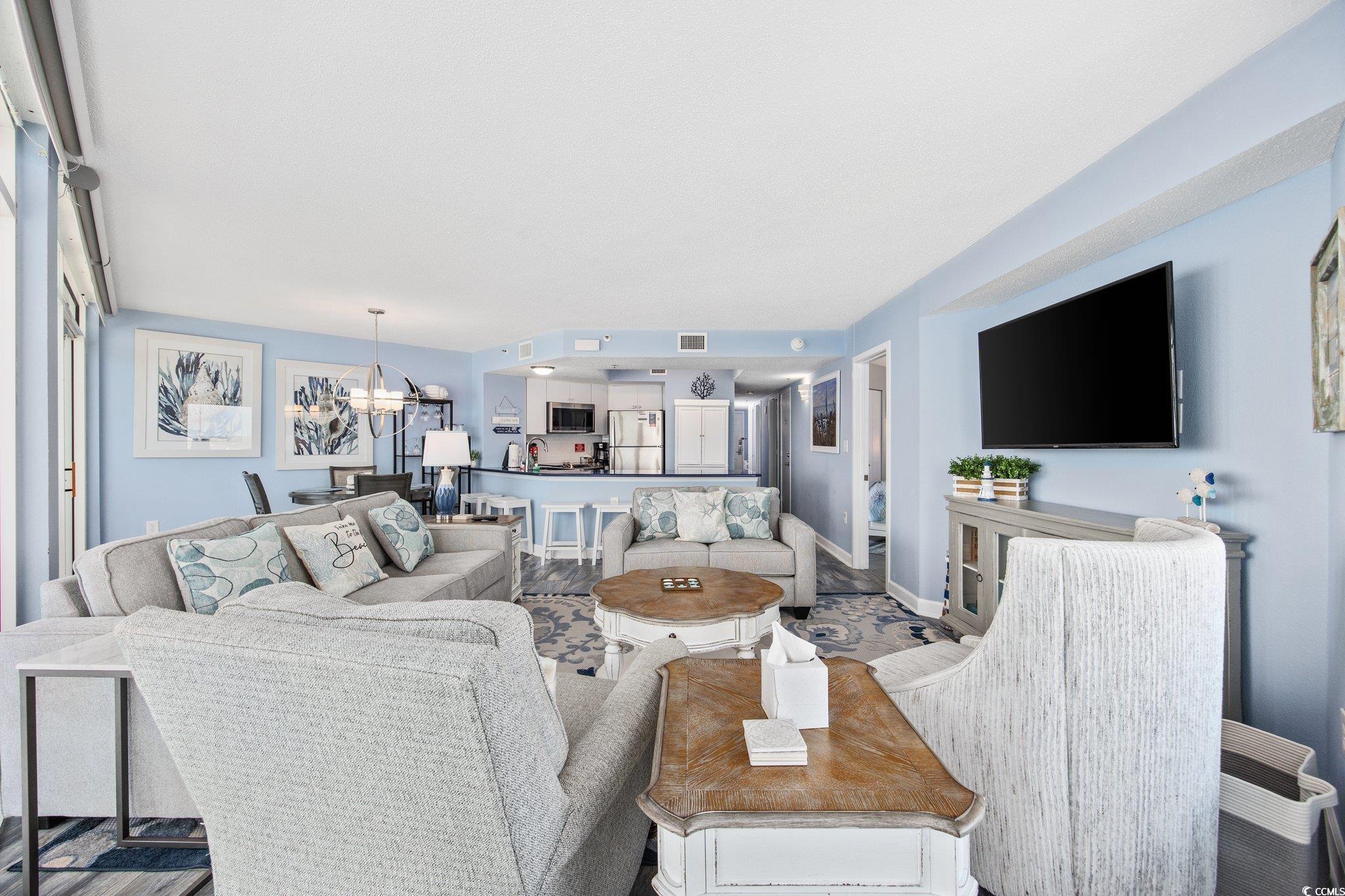 161 Seawatch Drive, Unit 1117 Myrtle Beach, SC 29572 - Photo 8 of 33 Living area with a chandelier and baseboards