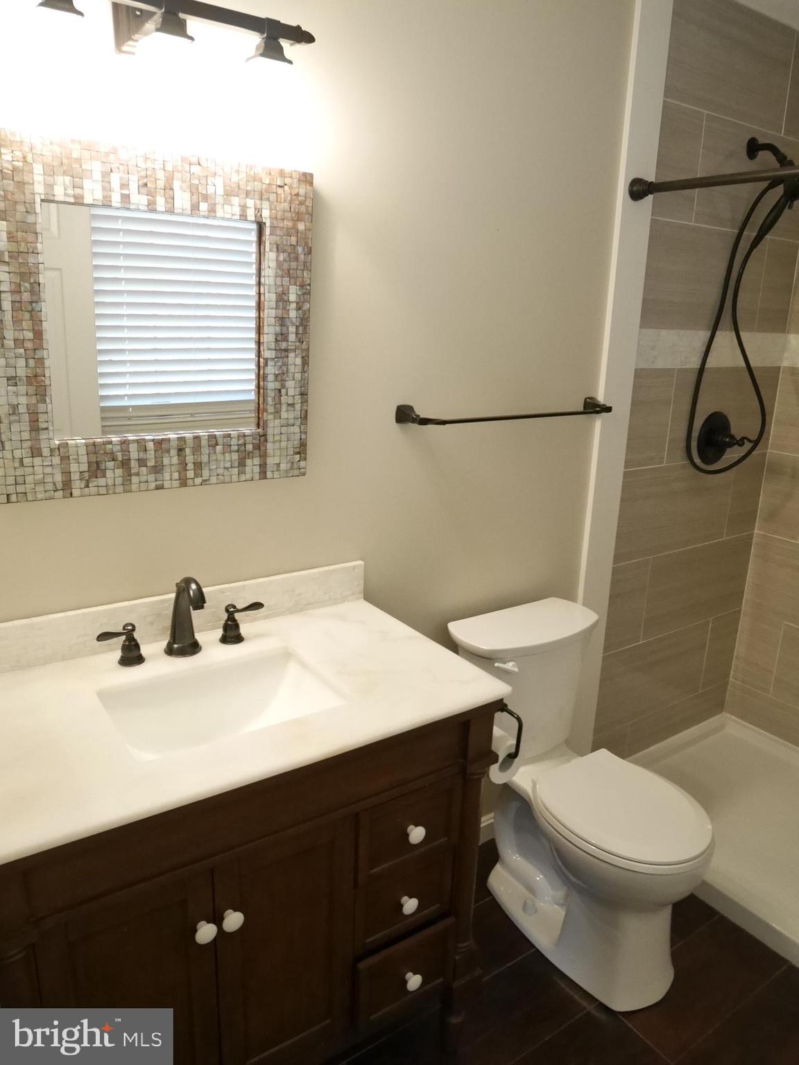 1705 Hambrooks Boulevard Cambridge, MD 21613 - Photo 12 of 22 a bathroom with a sink a toilet and a mirror