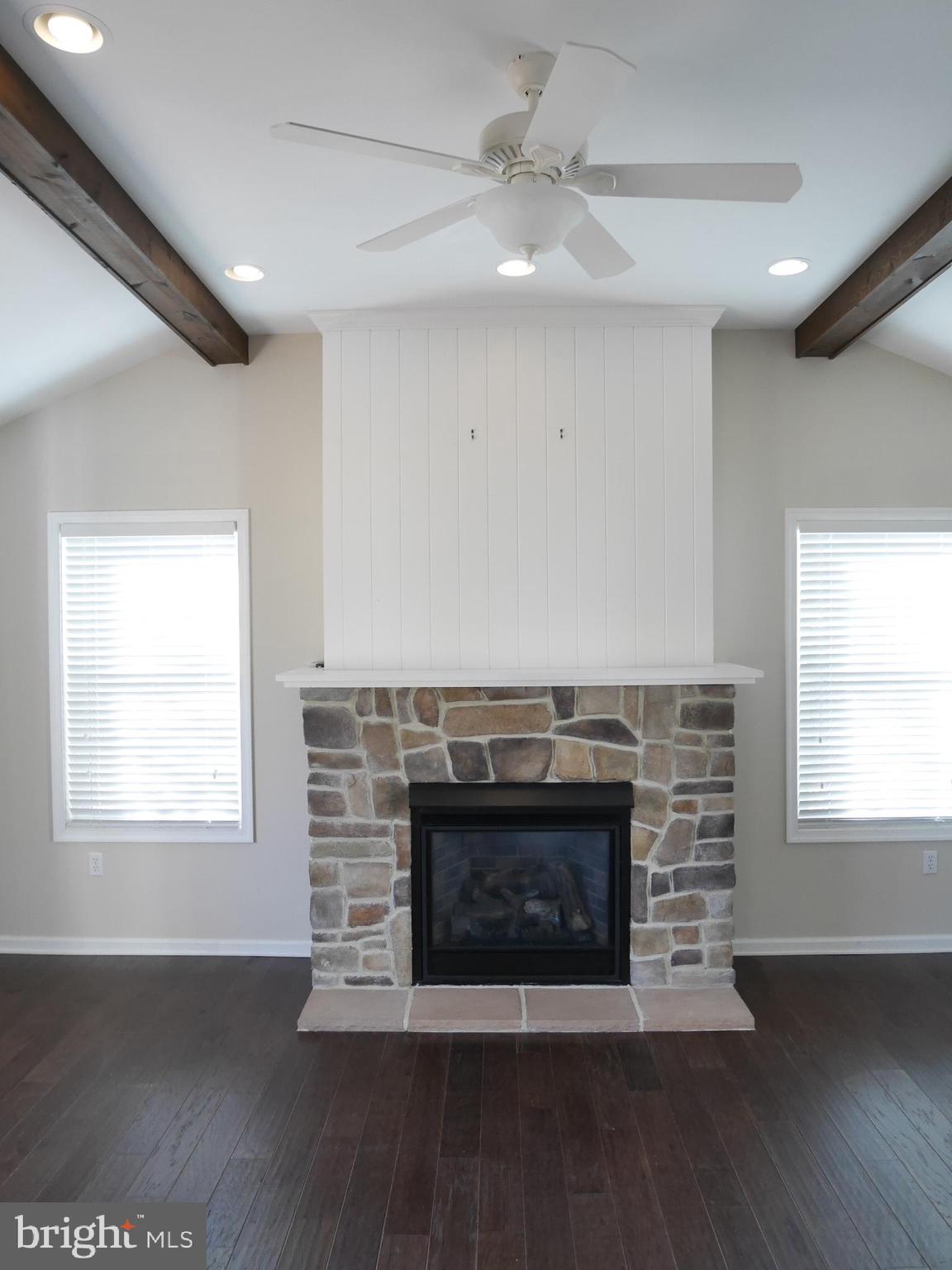 1705 Hambrooks Boulevard Cambridge, MD 21613 - Photo 3 of 22 a view of an empty room with wooden floor a fireplace and a window