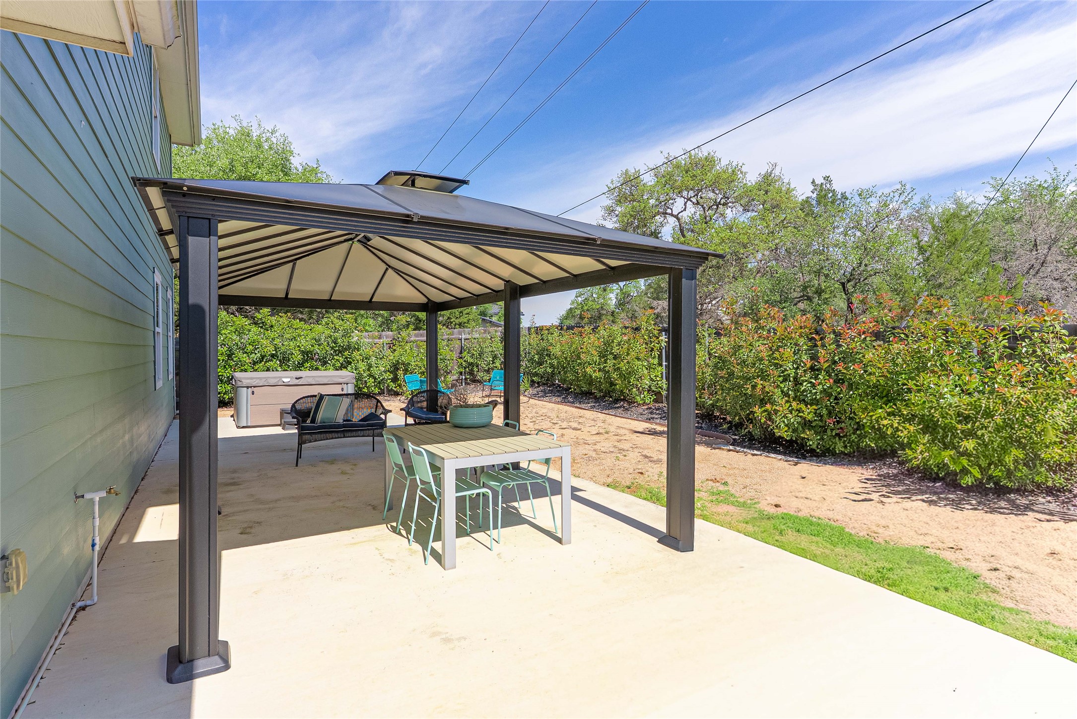 410 Summit Ridge Drive North Point Venture, TX 78645 - Photo 24 of 37 a view of a patio with a table and chairs under an umbrella with a small yard