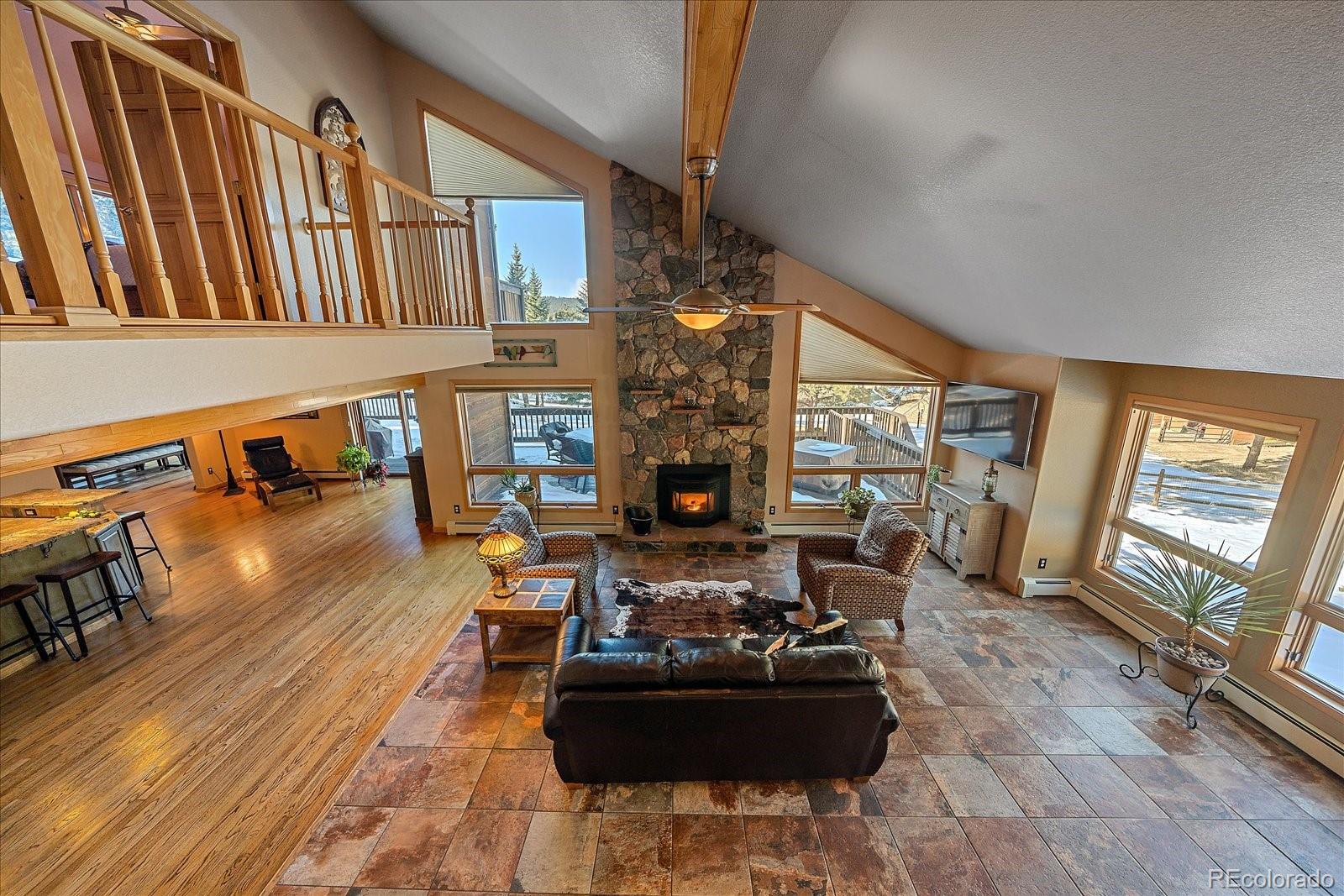 31196 Roberts Road Pine, CO 80470 - Photo 18 of 50 a living room with fireplace furniture and a large window
