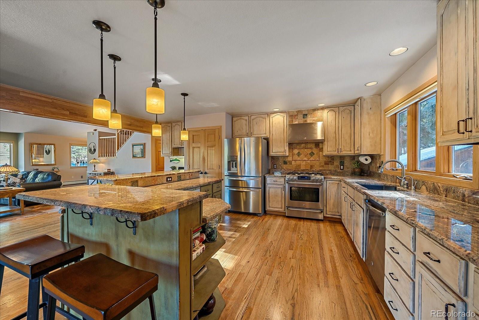 31196 Roberts Road Pine, CO 80470 - Photo 10 of 50 a kitchen with stainless steel appliances granite countertop wooden floors stove and cabinets