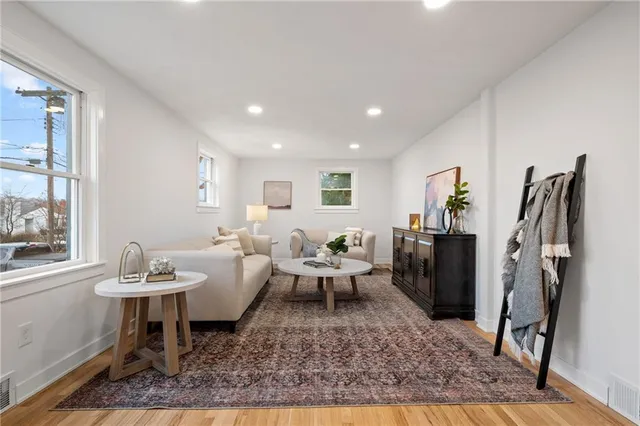 a living room with furniture a rug and a window