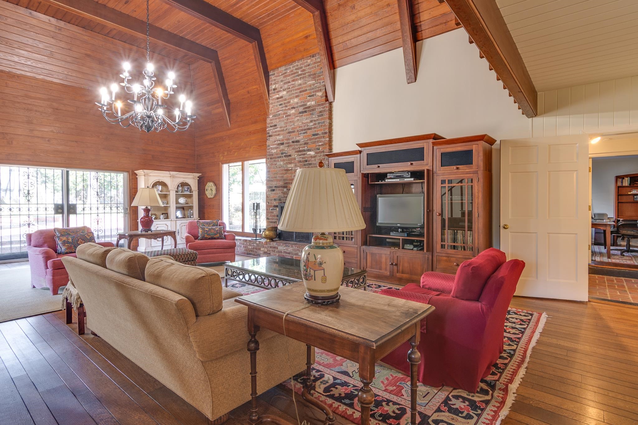 199 South Grove Park Road Memphis, TN 38117 - Photo 23 of 40 Living area featuring a high wooden beamed ceiling, hardwood / wood-style flooring, a chandelier, and wooden walls
