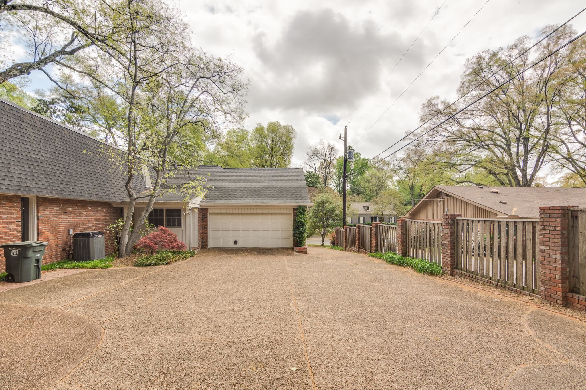 199 South Grove Park Road Memphis, TN 38117 - Photo 34 of 40 View of property exterior with roof with shingles, brick siding, driveway, and an attached garage