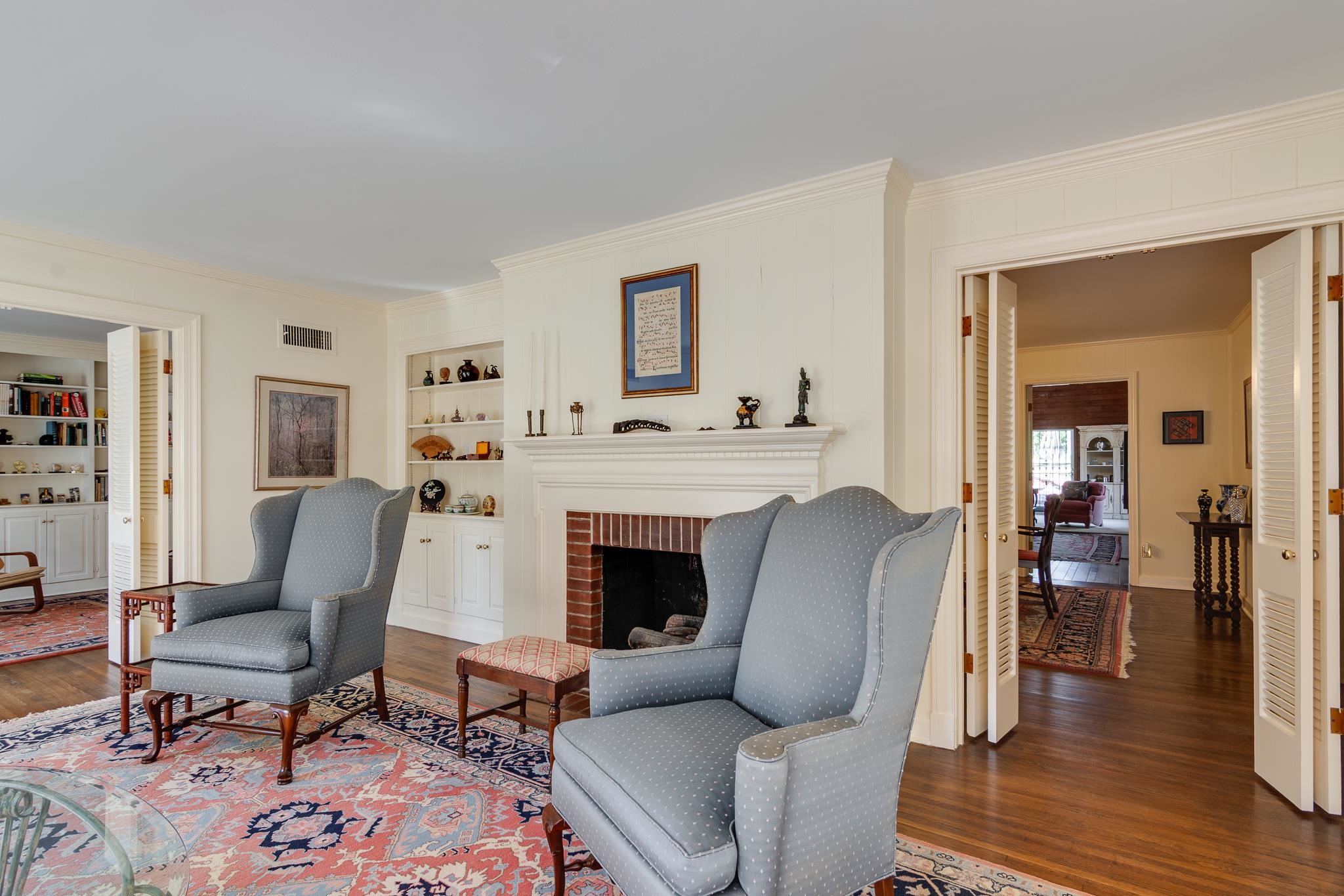 199 South Grove Park Road Memphis, TN 38117 - Photo 6 of 40 Living room featuring ornamental molding, wood finished floors, built in features, and a brick fireplace