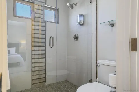 a spacious bathroom with a glass shower door and a sink