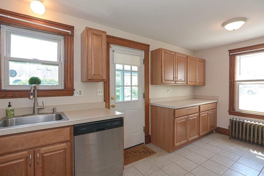 228 Pond Street Natick, MA 01760 - Photo 12 of 36 a kitchen with stainless steel appliances granite countertop a sink stove and cabinets